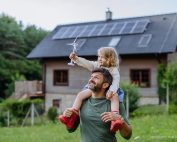 Klimatmål 2040. Pappa med barn på axlarna och hus i bakgrunden