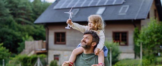 Klimatmål 2040. Pappa med barn på axlarna och hus i bakgrunden